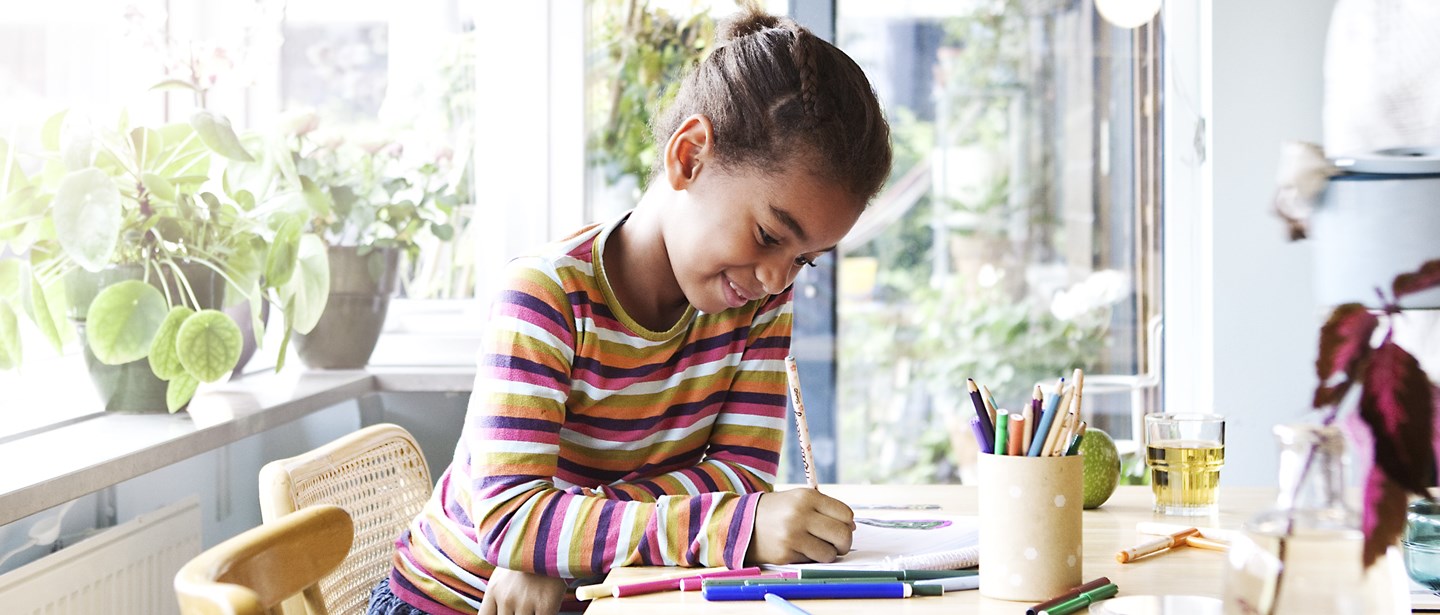 Ett barn gör sina läxor vid köksbordet.