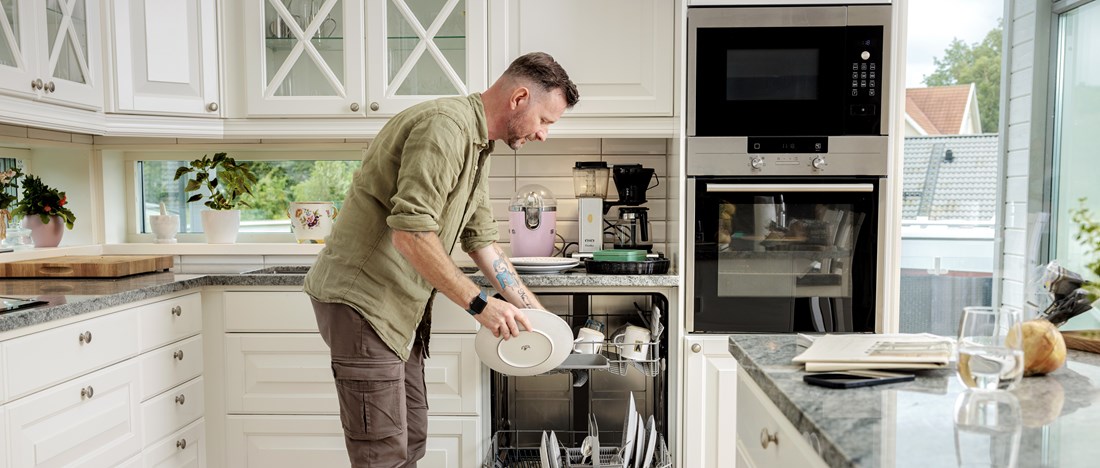 En man fyller diskmaskinen.