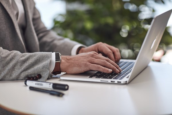 Hand som skriver på dator