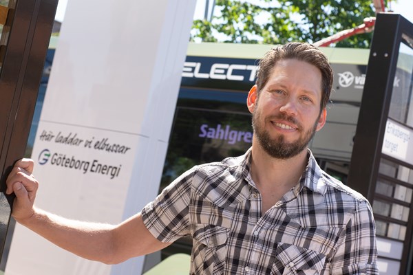 En man står framför en av Göteborg Energis elbilsladdare.