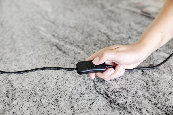 Hand som släcker en lampa.