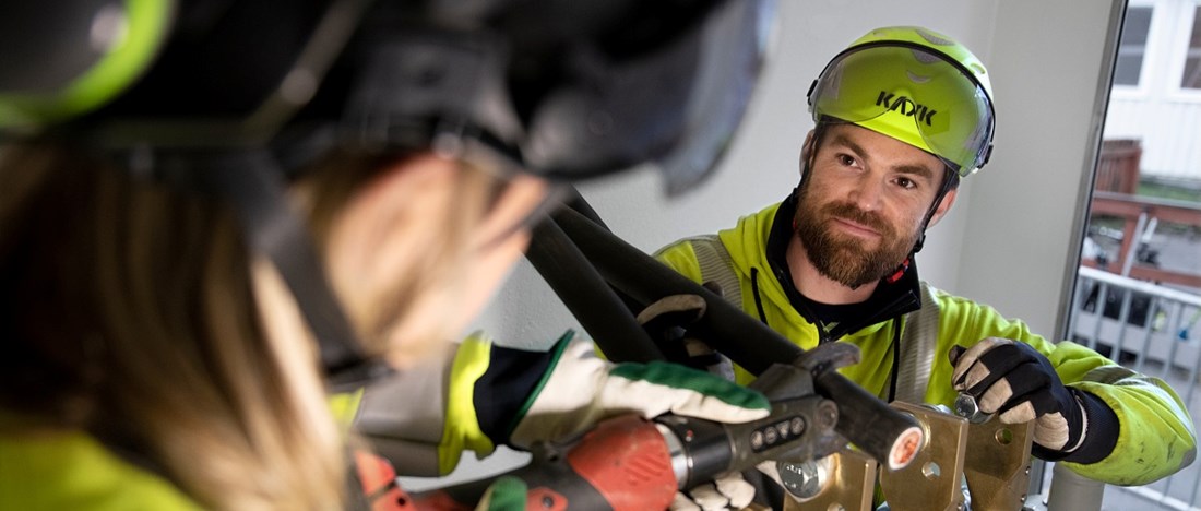 Två medarbetare utför jobb för elnätet.