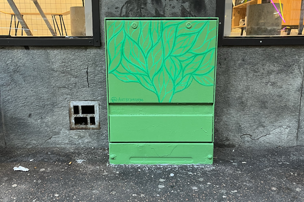 Ett målat elskåp på Andra långgatan med ljusgrön botten och mörkgröna blad