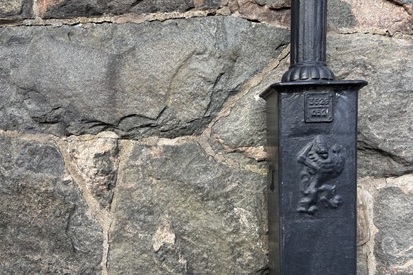 stenmur med en anrik lyktstolpe