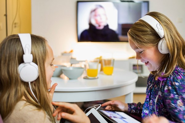 Två barn som skrattar framför sina ipads.