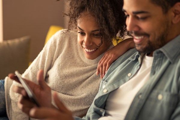 Två människor som kollar på en mobil.