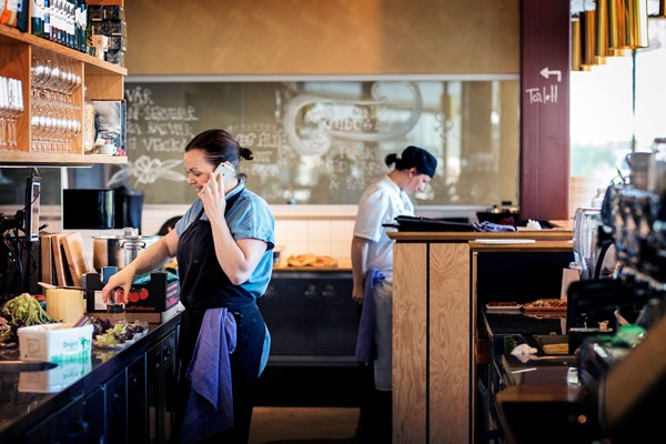 En kvinnlig barista gör en espresso i en restaurangmiljö.
