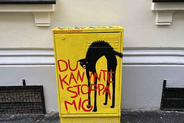 ett elskåp målat i gult och med en svart katt