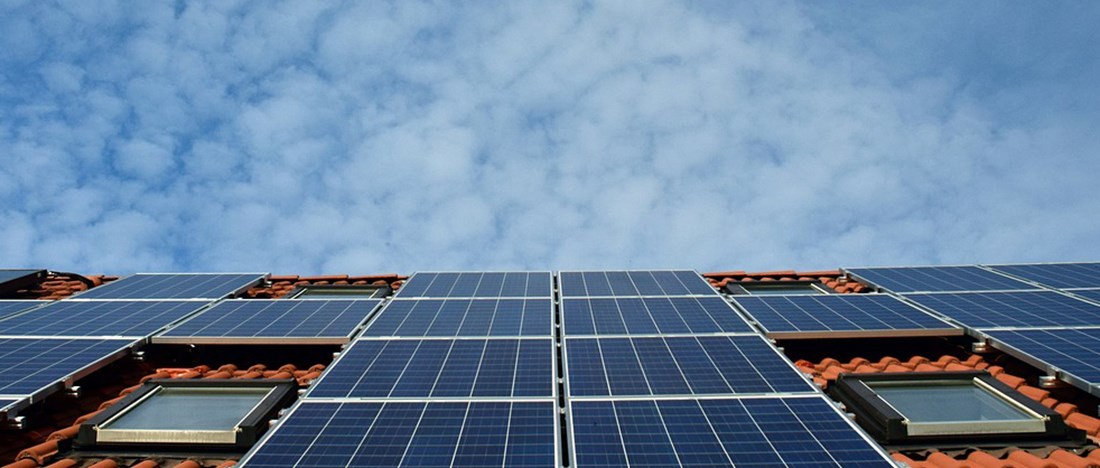 solpaneler på tegeltak mot blå himmel
