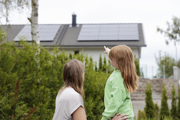 Två tjejer tittar på solceller på tak