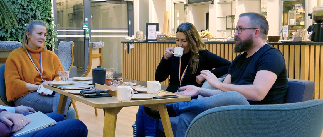 Göteborg Energis Jennie Sjöstedt och Isabella Andersson pratar med elnätskunden Magnus Eldén över en kopp kaffe.