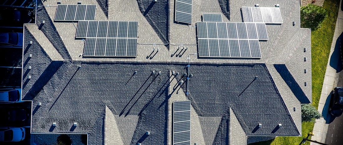 Flertalet solpaneler på ett stort tak.