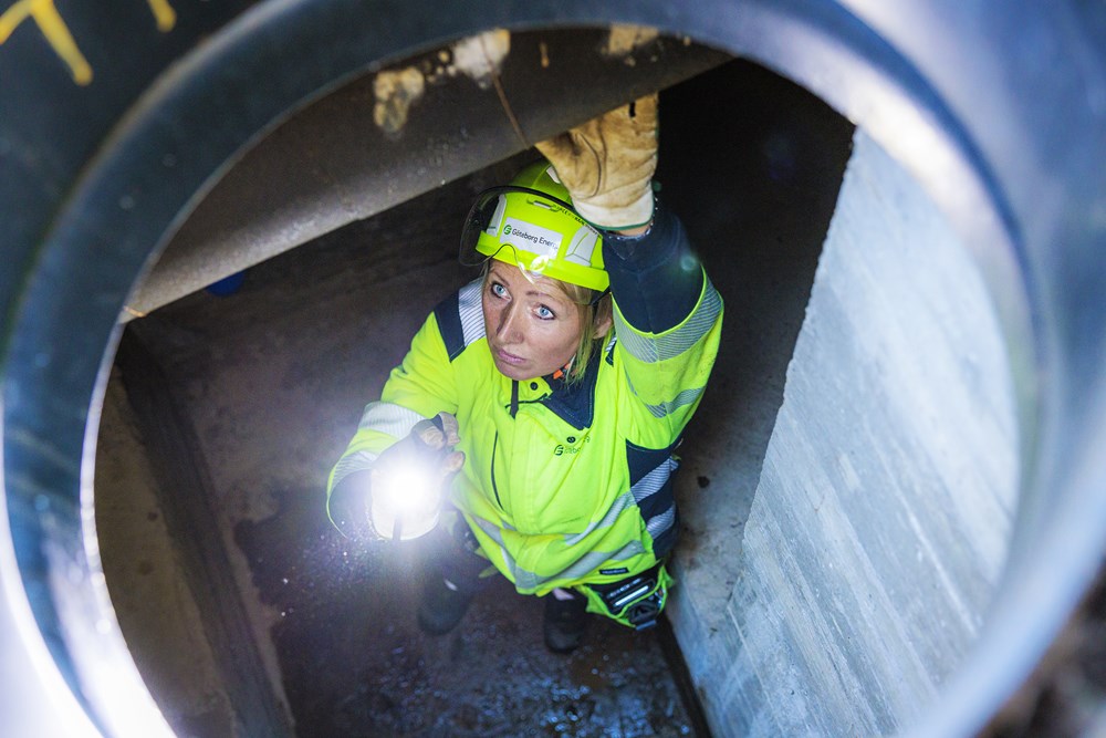 En av Göteborg Energis medarbetare iklädd varselkläder, nere i en tunnel.