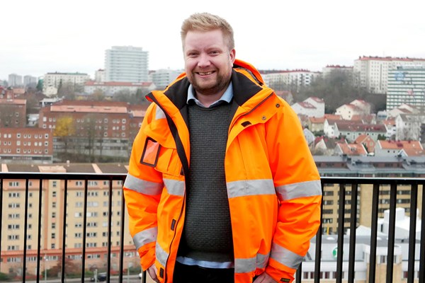 Martin Cagner står iklädd arbetskläder på PEAB Bostads lokal i Göteborg.