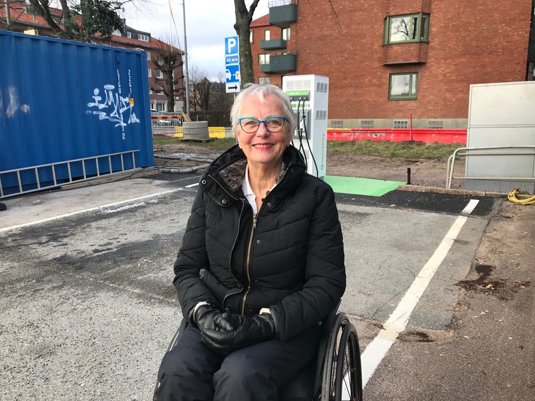 En kvinna sitter i en rullstol framför en av Göteborg Energis tillgänglighetsanpassade laddplatser.